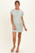 woman wearing a striped short sleeve maternity dress with a pocket in a light green color