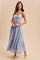 woman wearing a light blue maxi dress with embroidered details and a tiered skirt