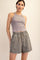 woman wearing a light gray ribbed tank top and matching high-waisted shorts with a relaxed fit