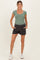 woman wearing a light green ribbed maternity top and black maternity shorts with a drawstring waist