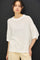 woman wearing a relaxed fit ivory oversized knit sweater with short sleeves and a wide neckline