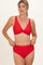 woman wearing a red twist front bikini top and high-waisted bikini bottoms