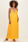 woman wearing a yellow maxi maternity dress with a halter neck and visible baby bump