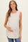 woman wearing a light beige ribbed maternity tank top and holding her baby bump