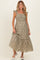 woman wearing a dusty olive green floral maternity maxi dress with ruffle straps and a smocked bodice, holding the hem