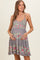woman wearing a floral print maternity dress with a fitted bodice and flared skirt, holding her baby bump