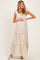 woman wearing a cream floral maternity maxi dress with ruffle straps and smocked bodice, holding her baby bump