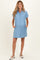 woman wearing a light blue short sleeve maternity shirt dress with buttons and pockets, styled casually