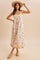 woman wearing a floral print maxi dress with spaghetti straps and a tiered design, accessorized with a straw hat