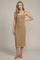 woman wearing a beige ribbed midi dress with a button-down front and spaghetti straps, standing with one hand on her hip