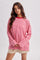 woman wearing a pink and red striped oversized long sleeve t-shirt with a crew neckline and relaxed fit