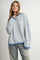 woman wearing a white and blue striped oversized sweater with a crew neck and dropped shoulders, paired with light blue jeans