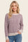 woman wearing a striped light purple and beige long sleeve sweater with a relaxed fit and ribbed hem
