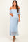 woman wearing a light blue off-the-shoulder maternity dress with a flowing silhouette and a visible baby bump