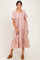 woman wearing a pink floral tiered midi dress with short sleeves and a scoop neckline