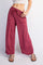 woman wearing loose-fitting maroon drawstring pants with front pockets and wide legs