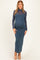woman wearing a teal ribbed maternity maxi dress with a sheer long sleeve overlay and showing her baby bump