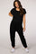 woman wearing a black maternity jumpsuit with short sleeves and a relaxed fit, showing her baby bump
