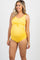 woman wearing a yellow maternity swimsuit with a tie detail, holding her baby bump, and wearing a straw hat outdoors