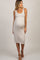 woman wearing a beige ribbed maternity dress and holding a black cat while showing her baby bump