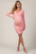 woman wearing a pink long sleeve maternity dress with ruching, highlighting her baby bump and paired with strappy sandals