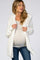 woman wearing a white fuzzy maternity cardigan over a light top, displaying her baby bump and styled with blue jeans