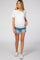 pregnant woman wearing a white maternity t-shirt and blue denim shorts with frayed hems