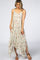 Woman wearing a sage green floral maternity maxi dress with a handkerchief hem and brown strappy sandals