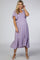woman wearing a lavender maternity dress with flutter sleeves and a smocked bodice, showcasing her baby bump