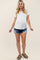 pregnant woman wearing a white maternity t-shirt and distressed denim shorts with sandals