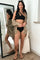woman wearing black one shoulder bikini and tan linen button down shirt cover up standing in front of mirror
