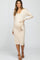 woman wearing a beige ribbed maternity dress with a v-neck and tie waist, showing her baby bump
