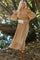 woman in off-the-shoulder floral smocked midi dress with white belt bag and brown boots in a wooded setting