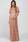 woman wearing a rose gold sequin maternity gown with a v-neck and belted waist, holding her baby bump
