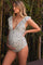 woman wearing a black and white polka dot maternity swimsuit with ruffle sleeves and showcasing her baby bump
