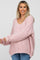 woman wearing a soft pink oversized maternity sweater with a v-neck and long sleeves