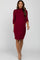 woman wearing a burgundy three-quarter sleeve maternity dress with a mock neck and tan ankle boots
