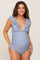woman wearing a blue floral maternity swimsuit with ruffle details and a visible baby bump