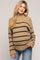 woman wearing a tan striped maternity sweater with a relaxed fit and slightly oversized sleeves, showing her baby bump