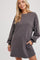 woman wearing a charcoal gray long sleeve sweatshirt dress with side pockets and relaxed fit