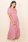 woman wearing a pink floral midi dress with puff sleeves and a square neckline, smiling against a neutral background
