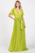 woman wearing a bright green pleated maxi dress with short flutter sleeves and a tie waist