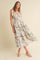 woman wearing a floral print midi dress with tie shoulder straps and tiered ruffle details