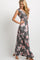 pregnant woman wearing a charcoal floral sleeveless maternity maxi dress against a white background