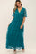 woman wearing a teal bohemian maxi dress with short sleeves and a V-neckline