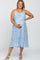 Smiling pregnant woman wearing a blue floral maternity midi dress with spaghetti straps and a waist tie.