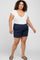 Plus size woman wearing a white scoop neck t-shirt and navy blue linen shorts with sandals