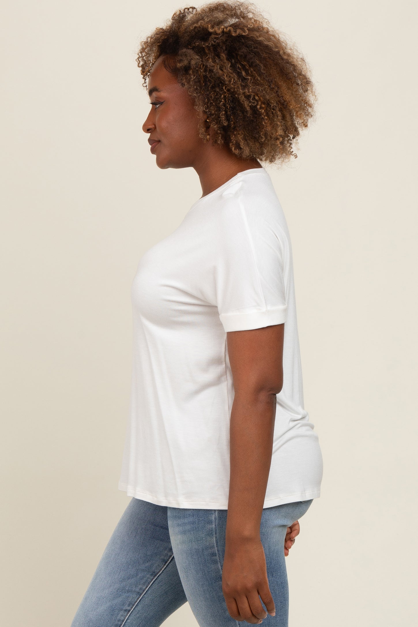 woman wearing a white short sleeve t-shirt with a relaxed fit and blue skinny jeans