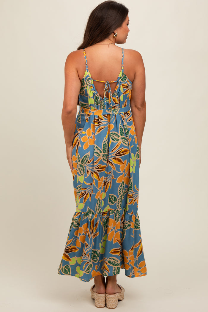 woman wearing a floral print maternity maxi dress with a tie-back detail and ruffled hem