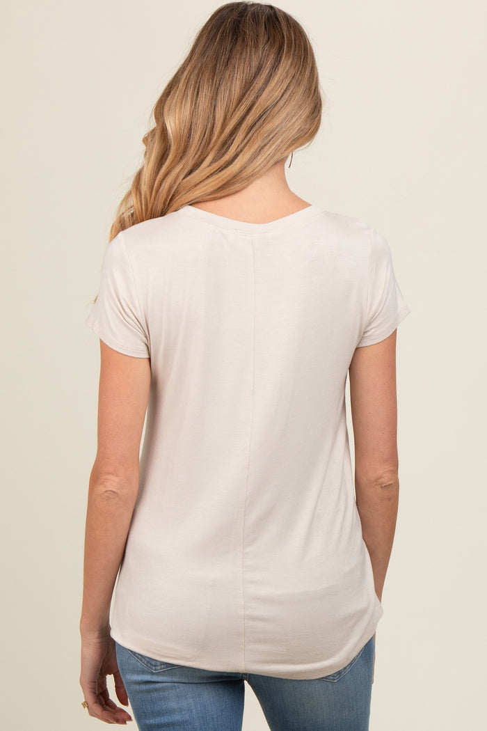 woman wearing a light beige maternity top with short sleeves, view from the back